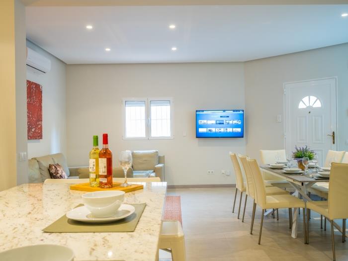 Modern and neat living room with sitting area, dining area and open plan kitchen