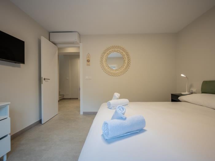 Bedroom with double bed, airconditioner, flatscreen TV