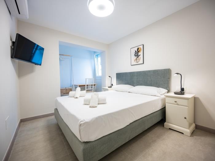 Bedroom with working table, flatscreen TV and double bed