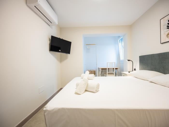 Bedroom with double bed, flatscreen TV, working table with chair