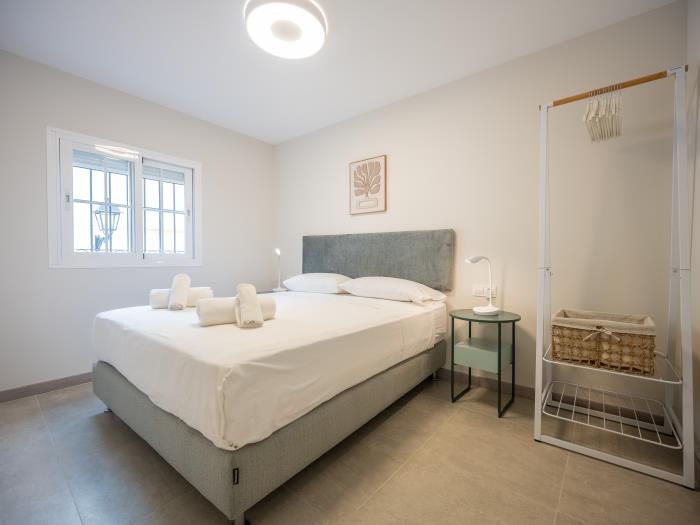 Bedroom with double bed, air conditioners, nightstands with lamps