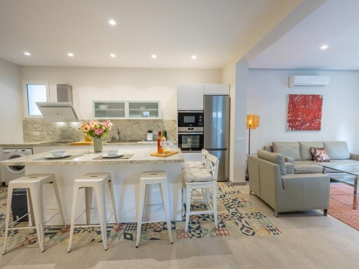 Sitting area with leather sofas around glass coffee table and dining area with table for 8