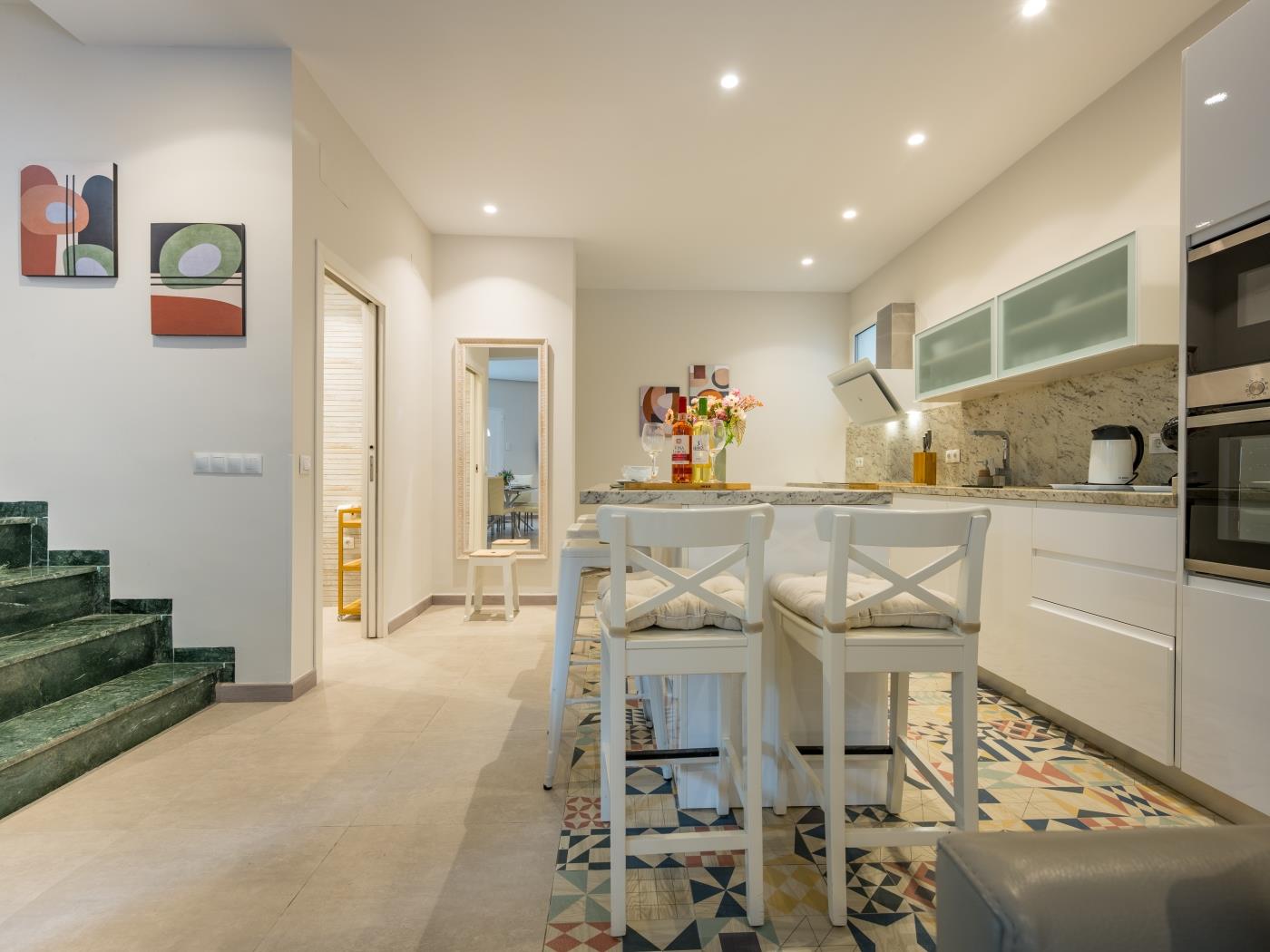 Open plan kitchen with island equipped with bar stools for five