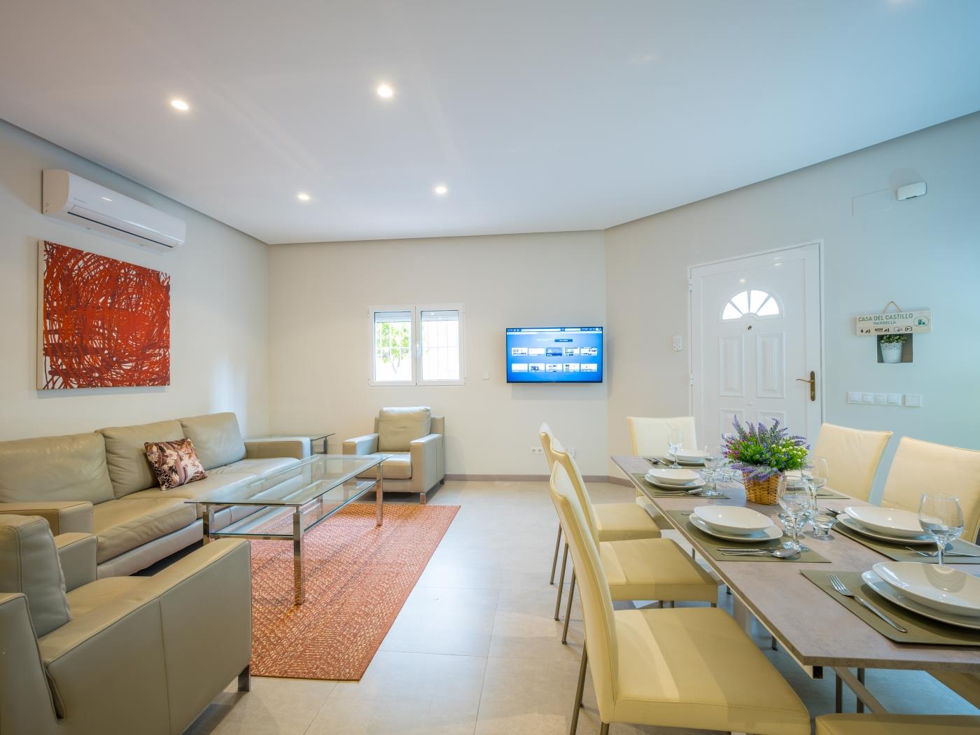 Sitting area with glass table surrounded with leather sofas in front of the flat screen