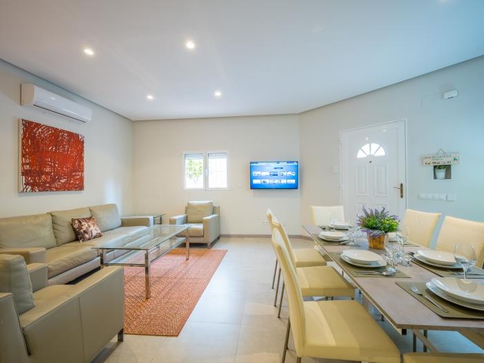 Sitting area with glass table surrounded with leather sofas in front of the flat screen